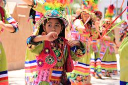 Auf dem Bild sieht man ein kleines Mädchen in traditioneller Kleidung in Chile tanzen.